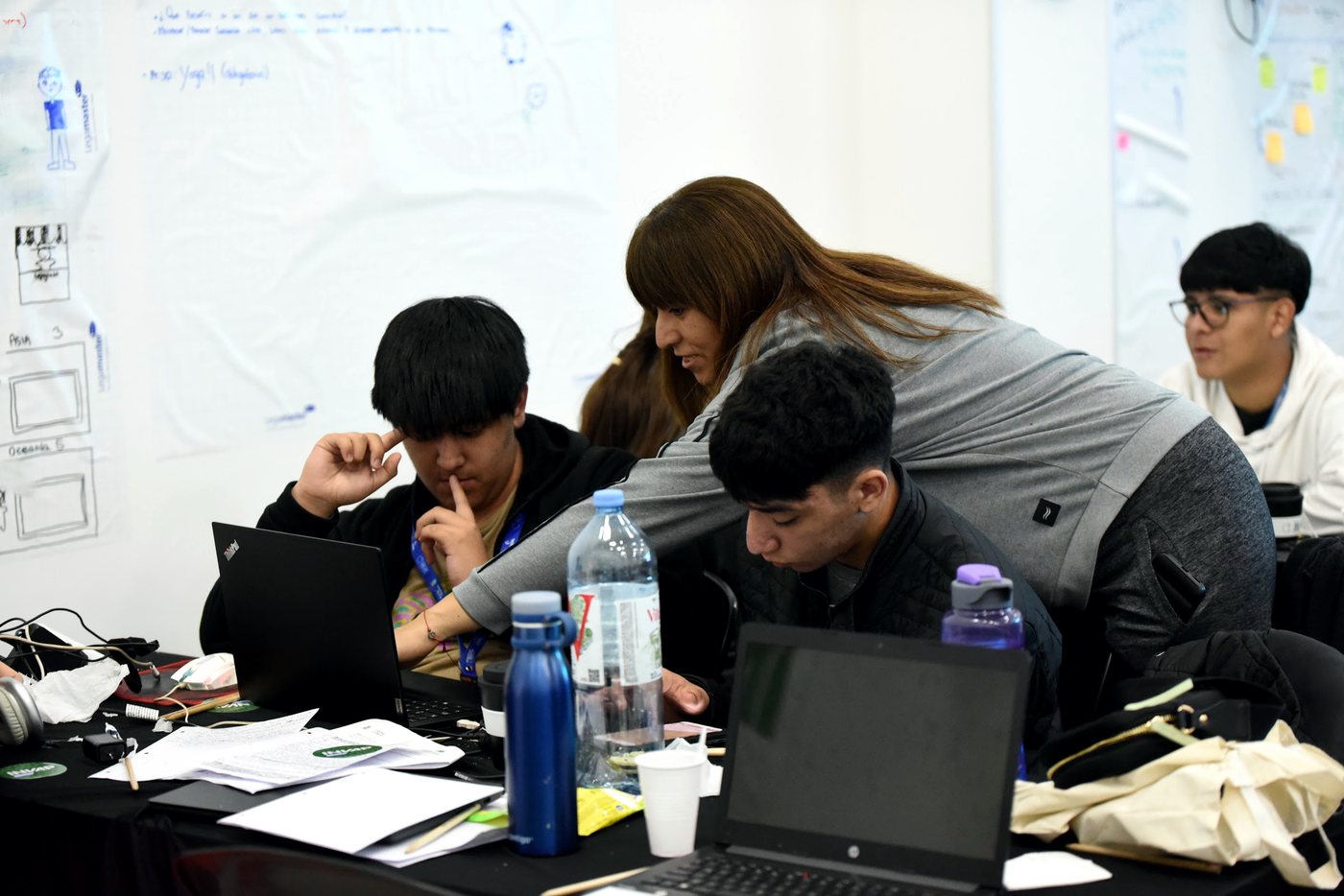 Un equipo trabajando alrededor de la mesa, con notebooks y anotaciones