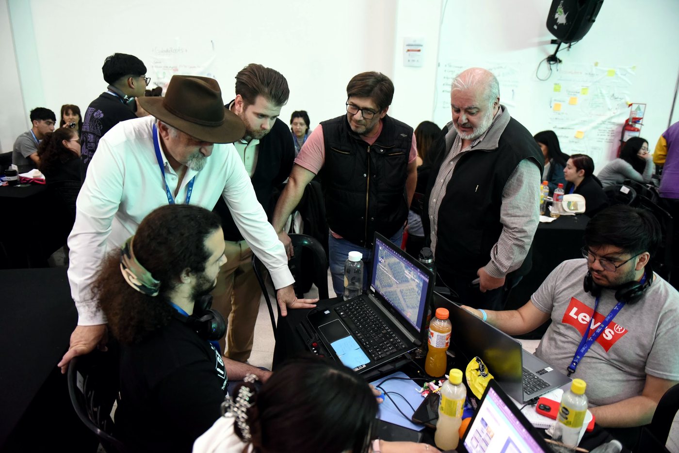 Mentores acompañando a un equipo sobre sus notebooks