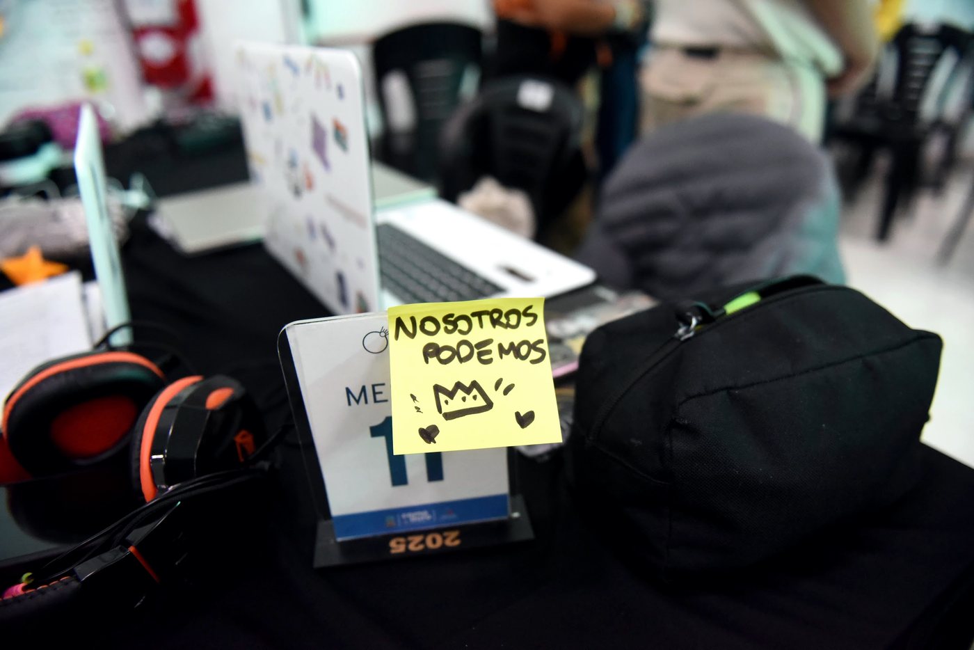 Un cartel escrito a mano que dice «nosotros podemos», pegado en una mesa de trabajo